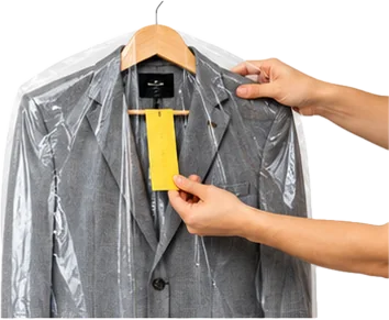 A suit in a dry-cleaning cover being checked by hand at the counter